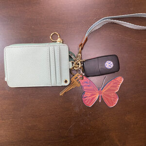 Butterfly keychain attached to keys and green wallet