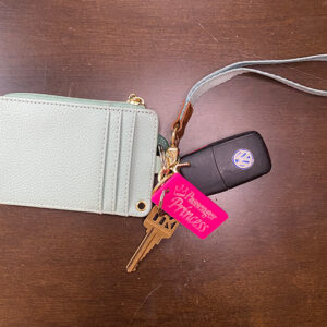 Pink keychain with the words "Passenger Princess" engraved into it with a crown above the "P" in Princess.