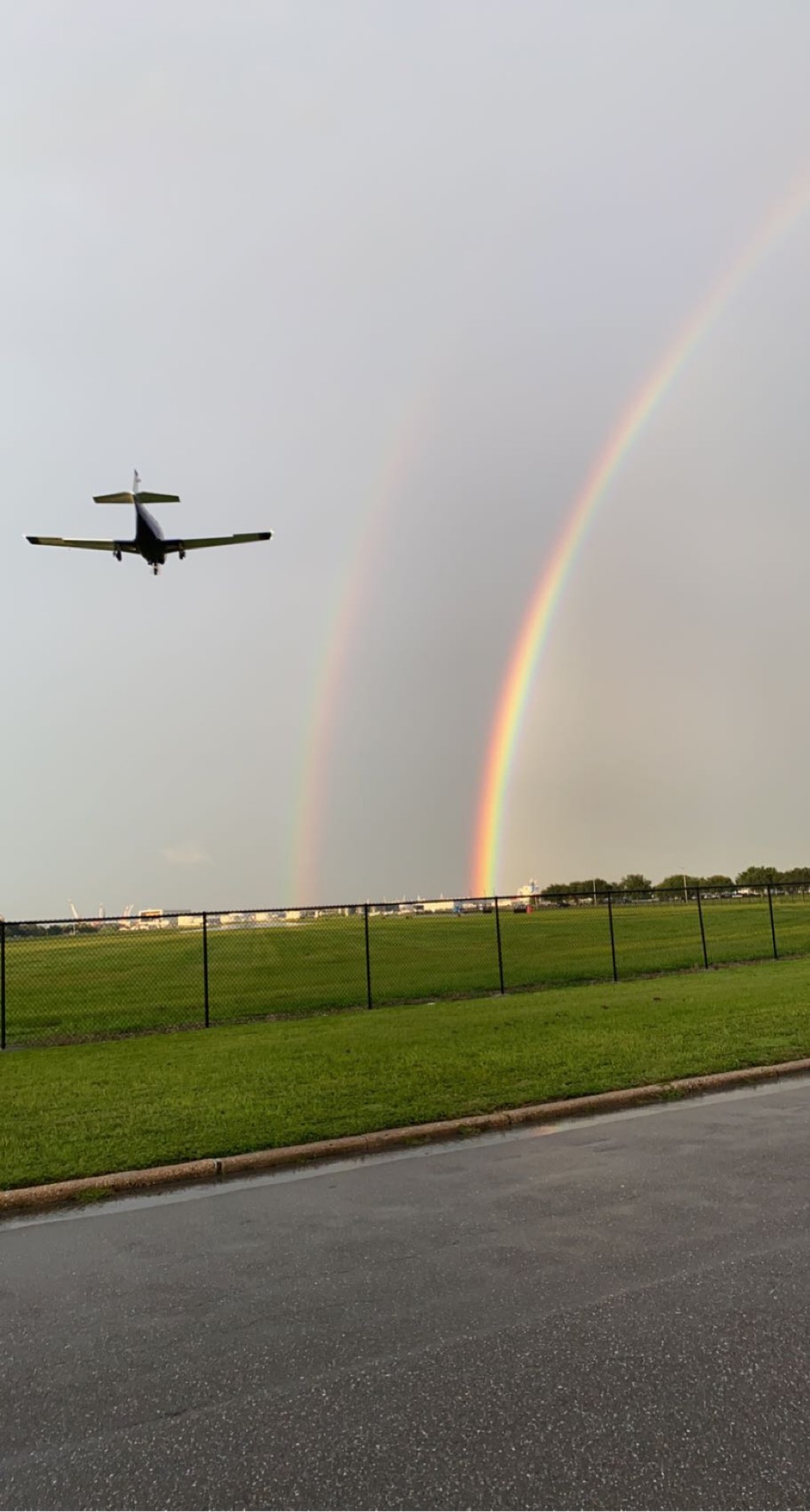 Photo taken at Davis Islands in Tampa, FL, capturing a double rainbow and a plane as it lands.